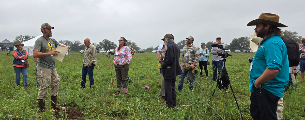 Speaker presents to attendees in the field.